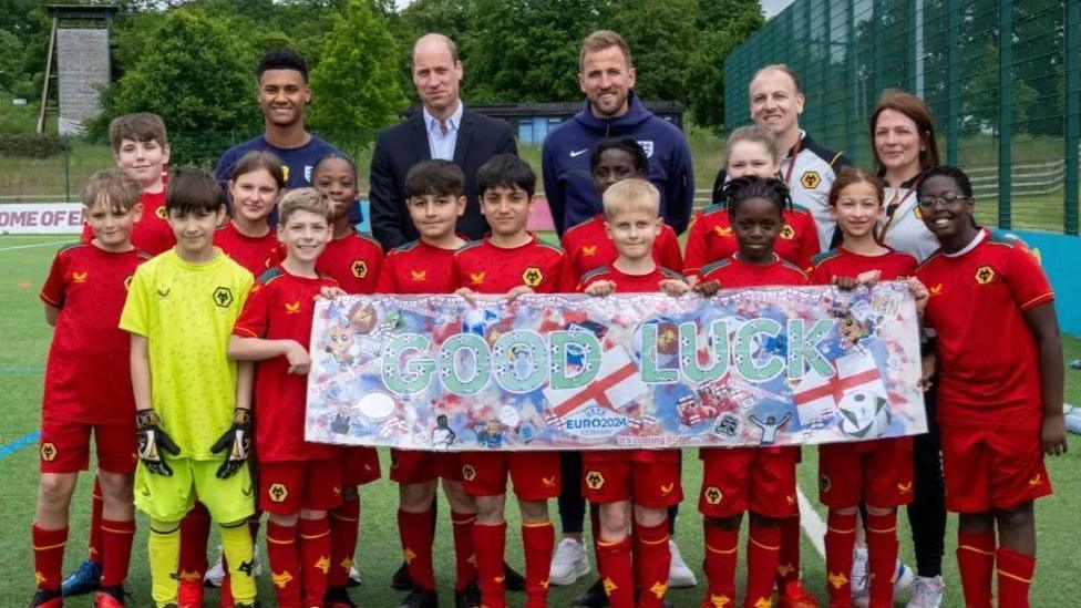 Pupils at the school standing with Prince William and the England team