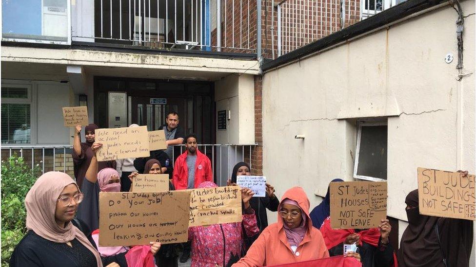 People with placards outside a residential block