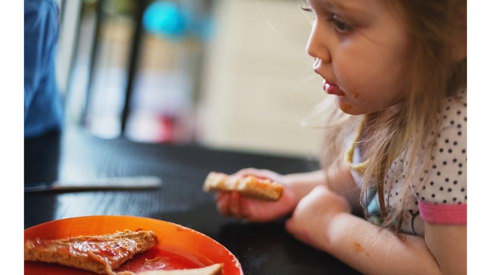 A child eats peanut butter