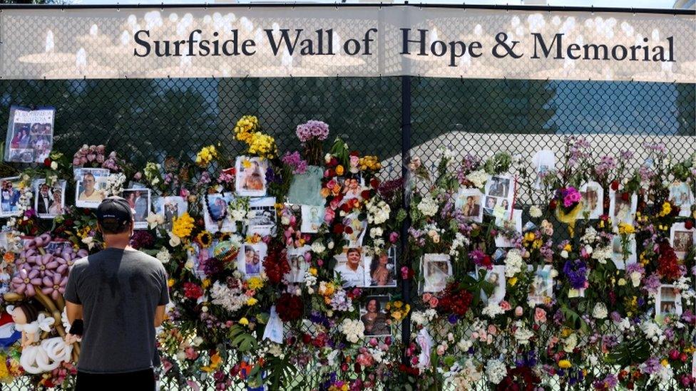 A man mourns at the memorial for victims of a partially collapsed residential building as the emergency crews continue the search and rescue operations for survivors, in Surfside, near Miami Beach, Florida, 2 July 2021