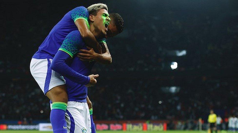 Brazil's Pedro celebrates scoring his goal against Tunisia as a laser is shone onto his face