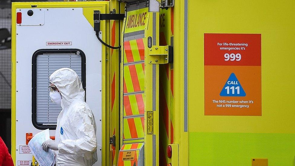 Ambulance with staff member in white suit