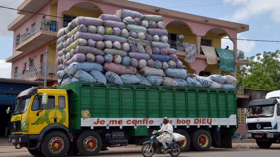 A photo taken on June 4, 2016 in Bouake shows a Malian lorry with the words "I trust God with my life" written on it, loaded with various goods on its way to Bamako, Mali. / AFP PHOTO / ISSOUF SANOGOISSOUF SANOGO/AFP/Getty Images