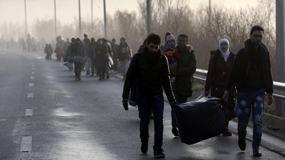 Migrants and refugees walk to cross the Greece-Macedonia border near the village of Idomeni, on 1 March, 2016.