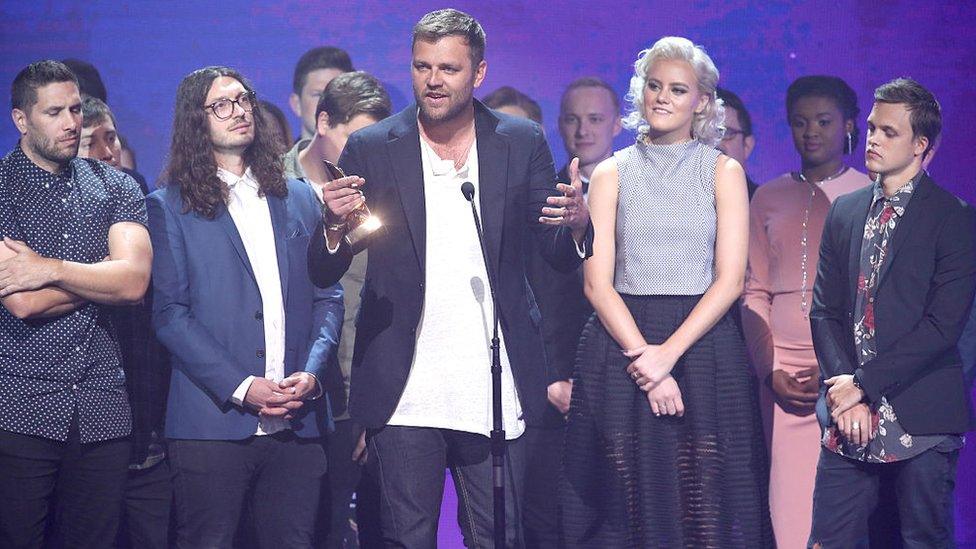 Joel Houston of Hillsong United accepts an award onstage during the 2016 Dove Awards in Nashville, a Christian music awards show