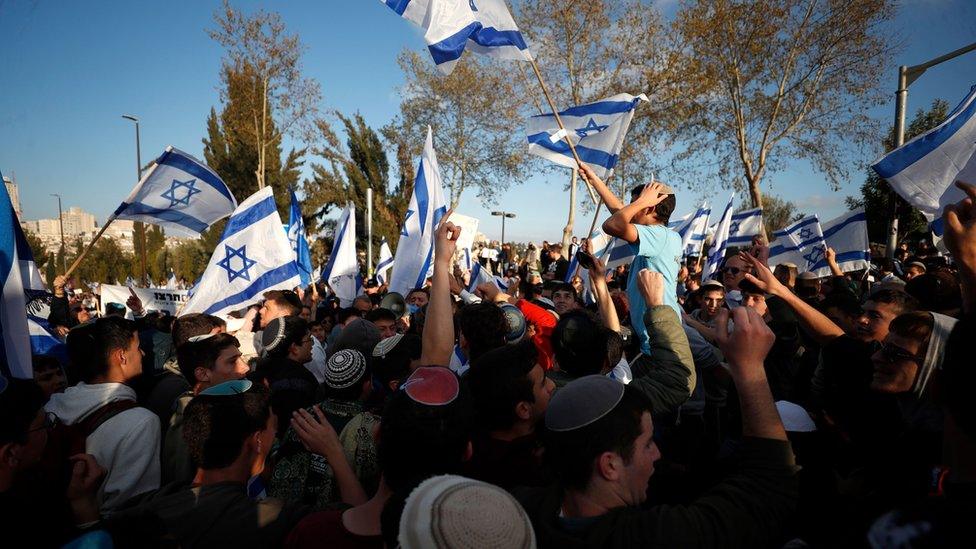 Supporters of the Israeli government gather outside the Israeli parliament in Jerusalem (27 March 2023)