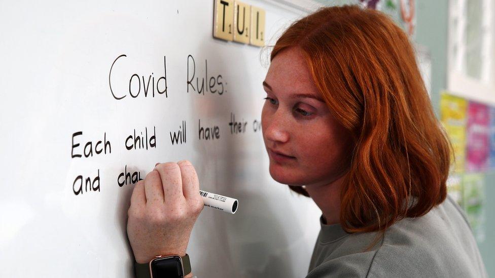 Kaipara Flats school teacher Allie Stucke writes Covid-19 instructions on the white board for the small number of students returning