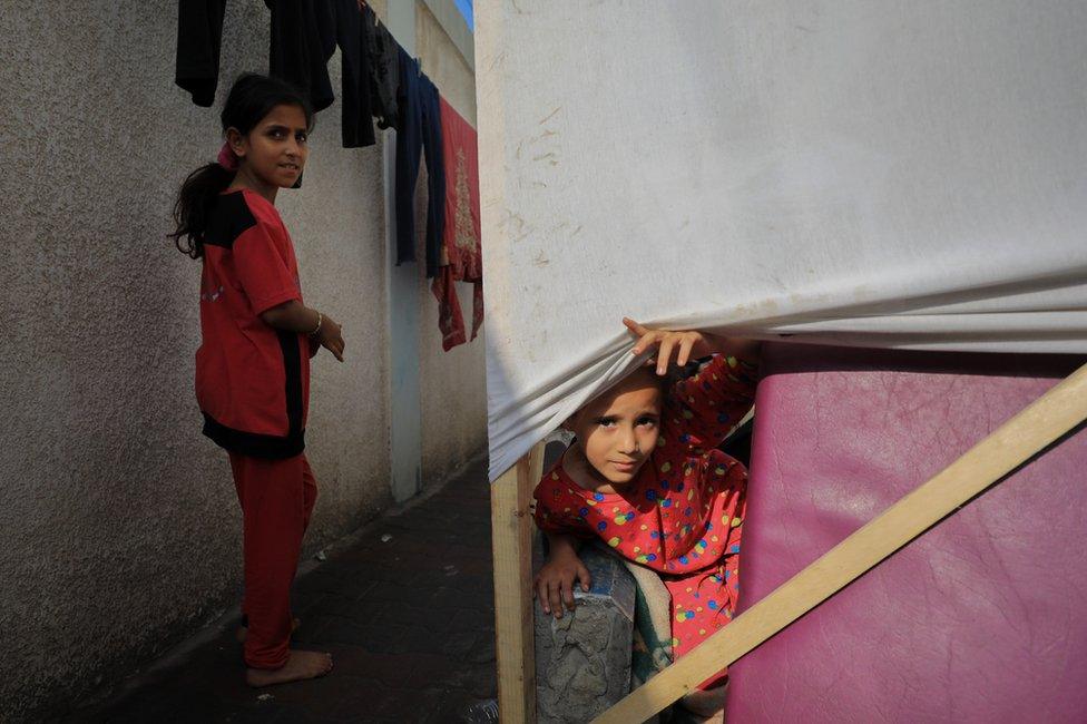 Girls living in a makeshift lean-to in the courtyard of a school in Deir al-Balah.