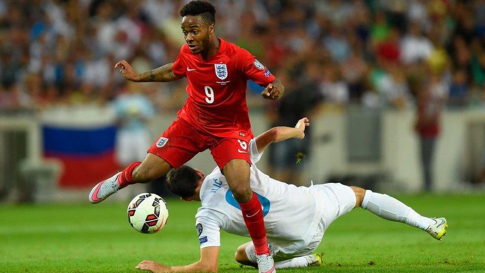 Raheem Sterling jumps over a challenge from Branko Ilic of Slovenia