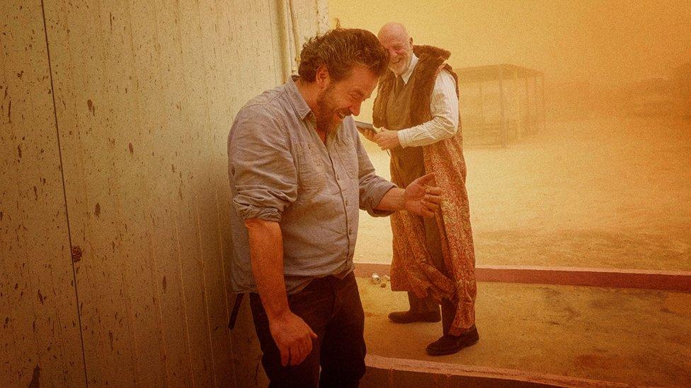 Artistic director Dominic Dromgoole and cast member Keith Bartlett during a sandstorm at the Zaatari refugee camp in Jordan