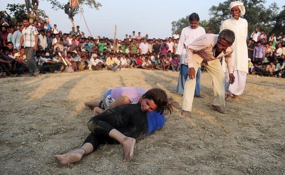 Indian women wrestlers perform during a traditional wrestling competition at a fair held annually on October 7 in Rampur village, near Allahabad on October 7, 2015.