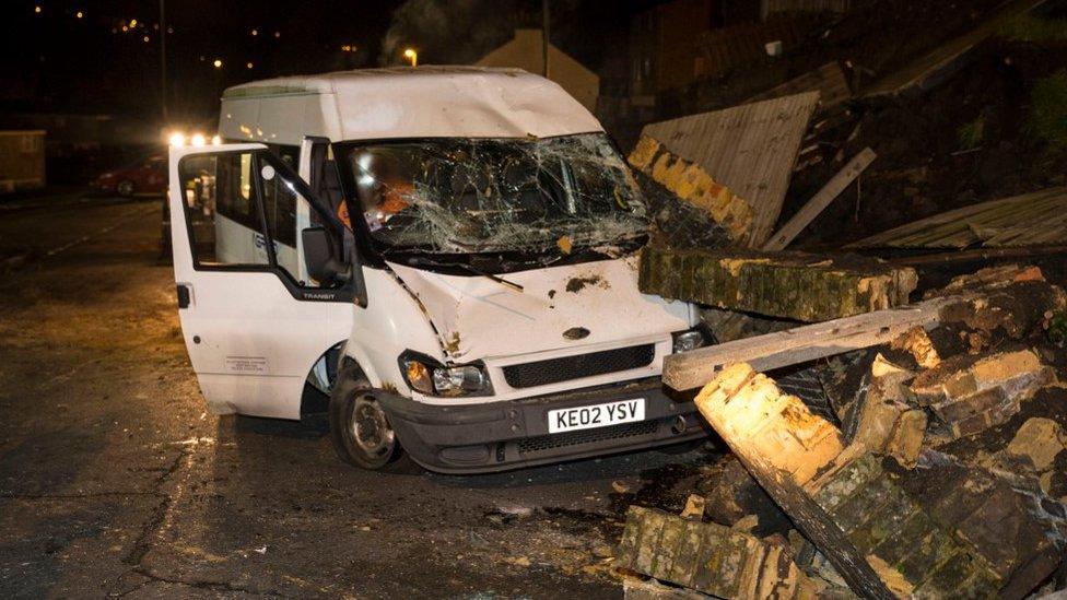 A van covered in rubble