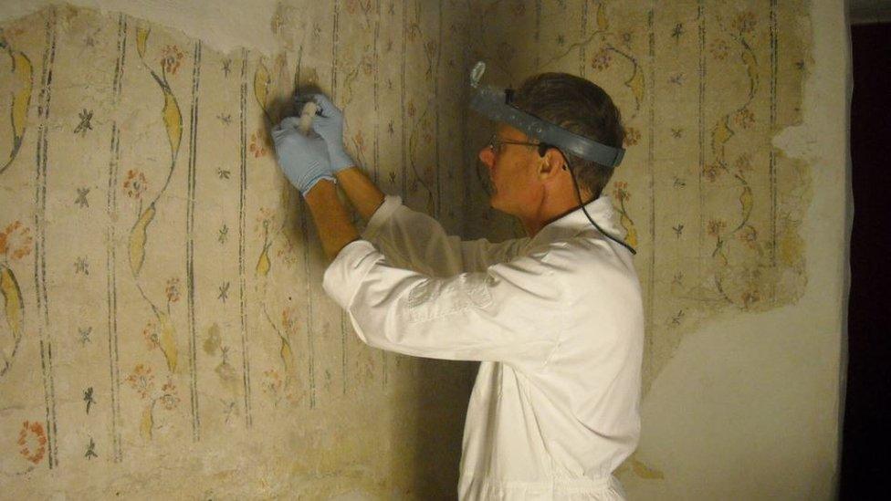 Peter Martindale working to restore the paintings