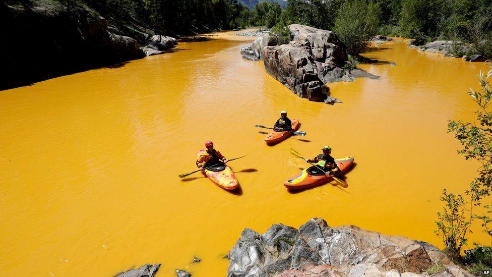 People kayak in the Animas River near Durango, Colorado, on 6 August in water coloured from a mine waste spill.