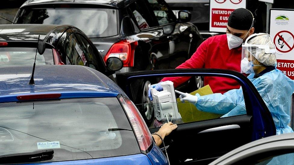 Medical staff help suspected cases of Covid-19, arriving by car and waiting for available beds, outside the hospital for infectious diseases Cotugno in Naples, Italy, 12 November 2020