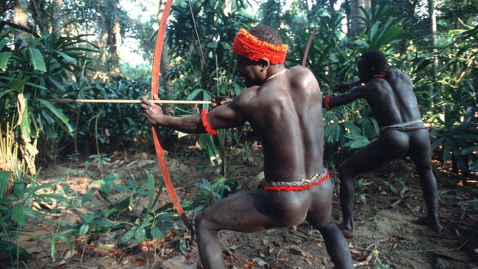 Two Jarawa men shooting a bow and arrow