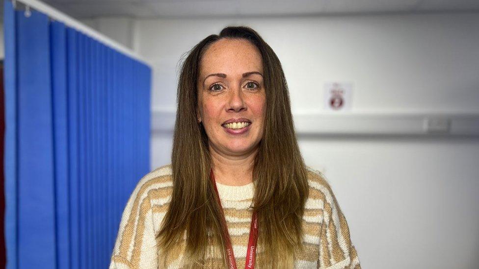 Lady infront of nursing curtain