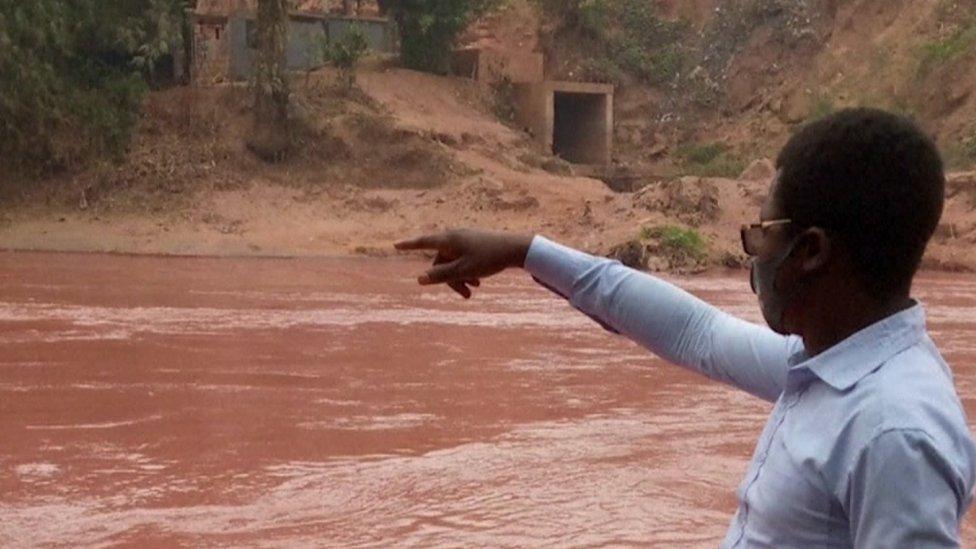 Man pointing at red river