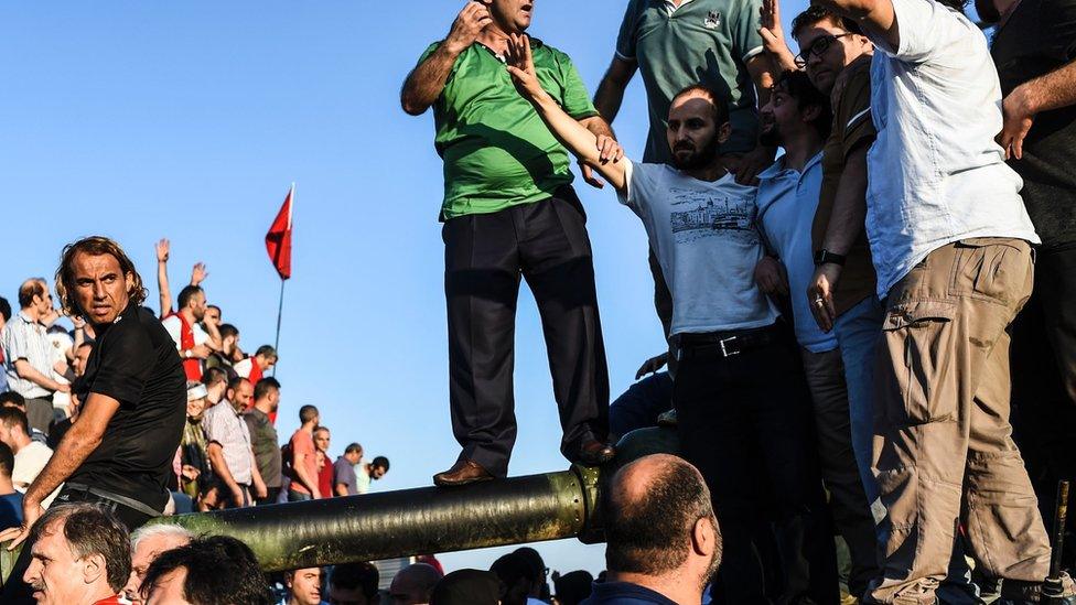 People stand and celebrate on an army tank after taking over military position on a major Bosphorus bridge in Istanbul (16/07/2016)