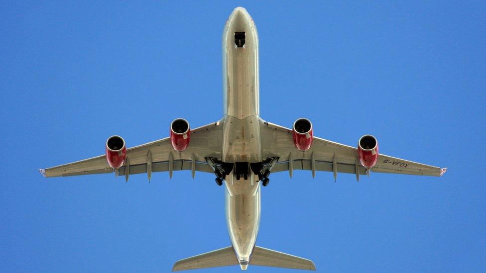 A Virgin Atlantic Airways Airbus A340-642 (call sign G-VFOX) deploys its landing gear on its approach to Heathrow Airport, seen from underneath the flight path in Barnes, south-west London, 14/07/2009