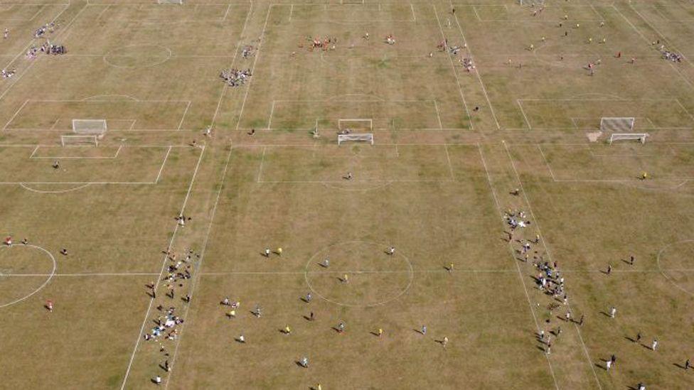 An overhead view shows people playing games of football on the pitches at Hackney Marshes in north east London on September 10, 2023, as the late summer heatwave continues.