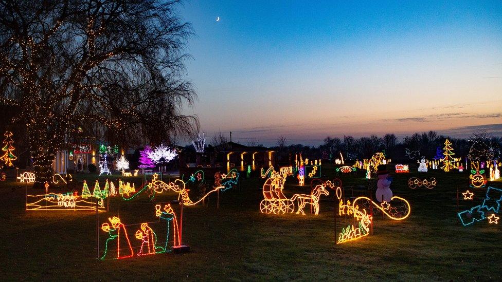 A large garden decorated with numerous Christmas-themed models.