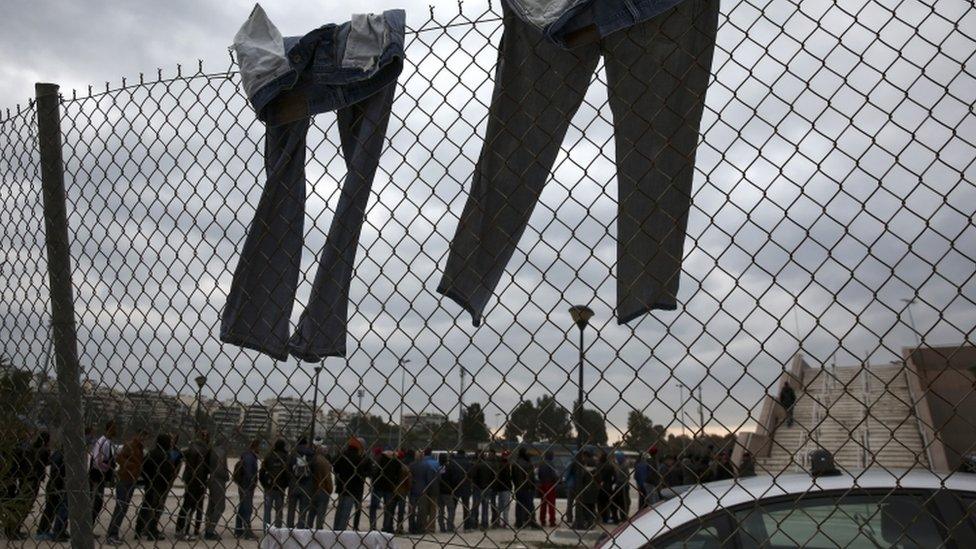 Migrants queue in Athens