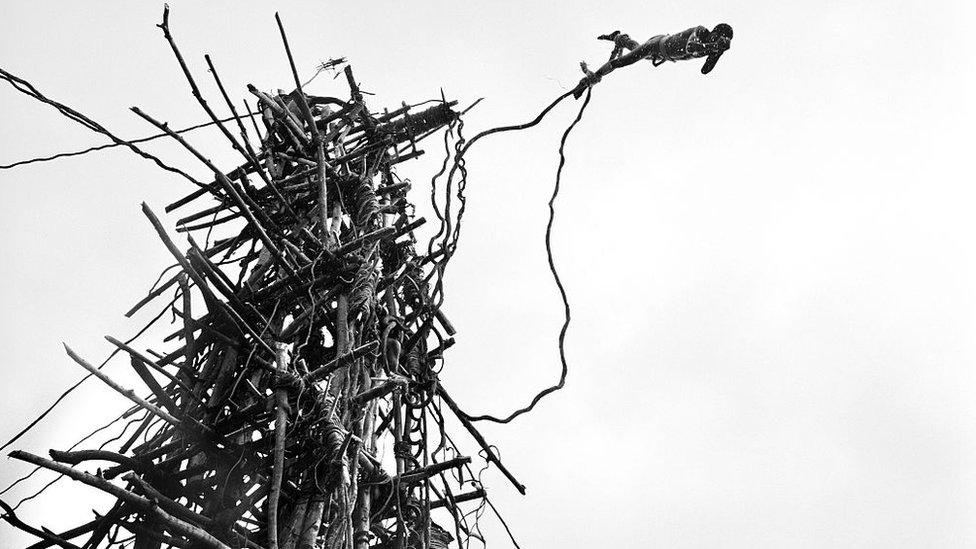 A man dives off the hand-built tower. For three months of the year on the remote South Pacific island of Pentecost, between March and June when the vines are strong, the tradition of land diving takes place. Local tribes around Lonohore gather to perform the land diving as a sporting spectacle for the tourists visiting the island.