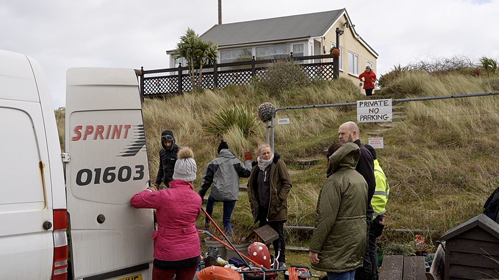 People evacuating one of the homes in Hemsby on Monday morning