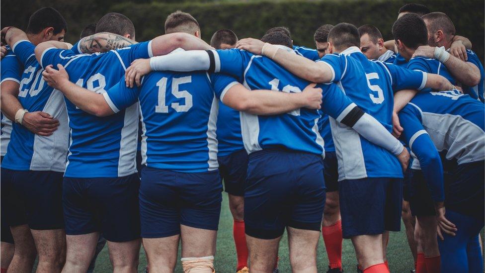 Young rugby team in a group huddle