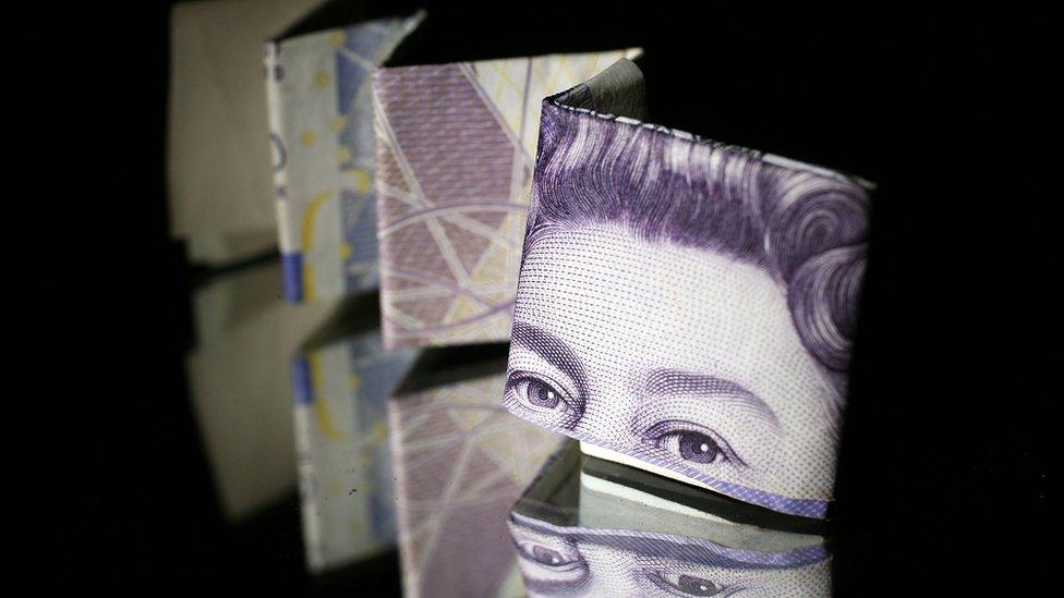 A photo illustration of a British 20 pound note reflected in glass