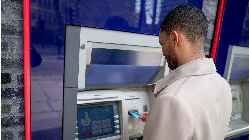 Man withdrawing money - stock shot