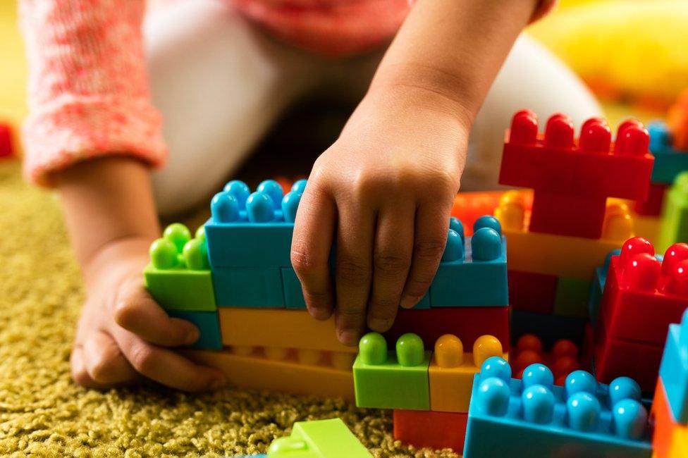 A child plays with plastic bricks