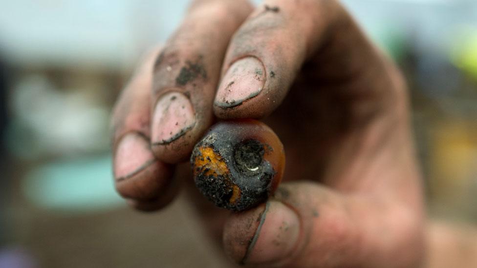 Bronze Age amber bead in archaeologist's hand