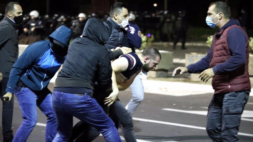 A group of protesters appear to scuffle in the street