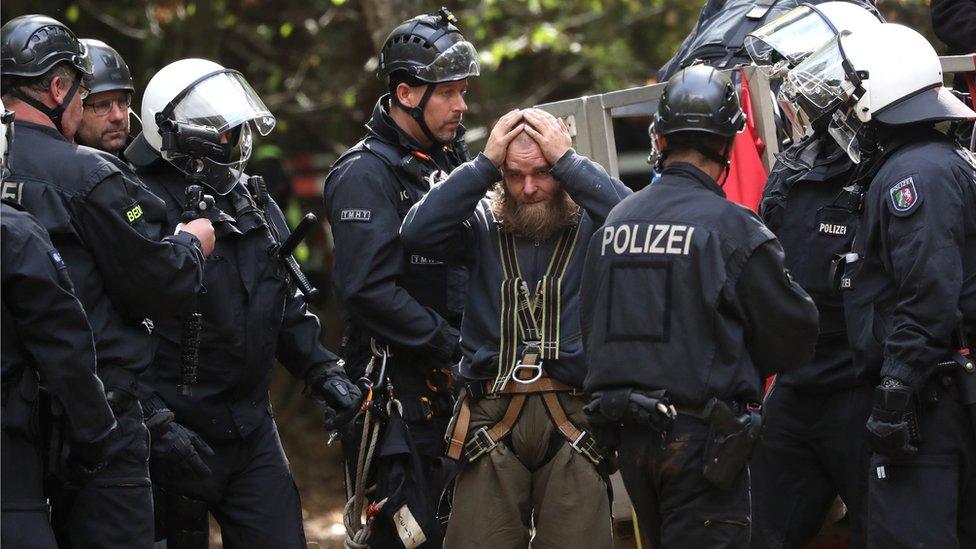 An activist is escorted by police