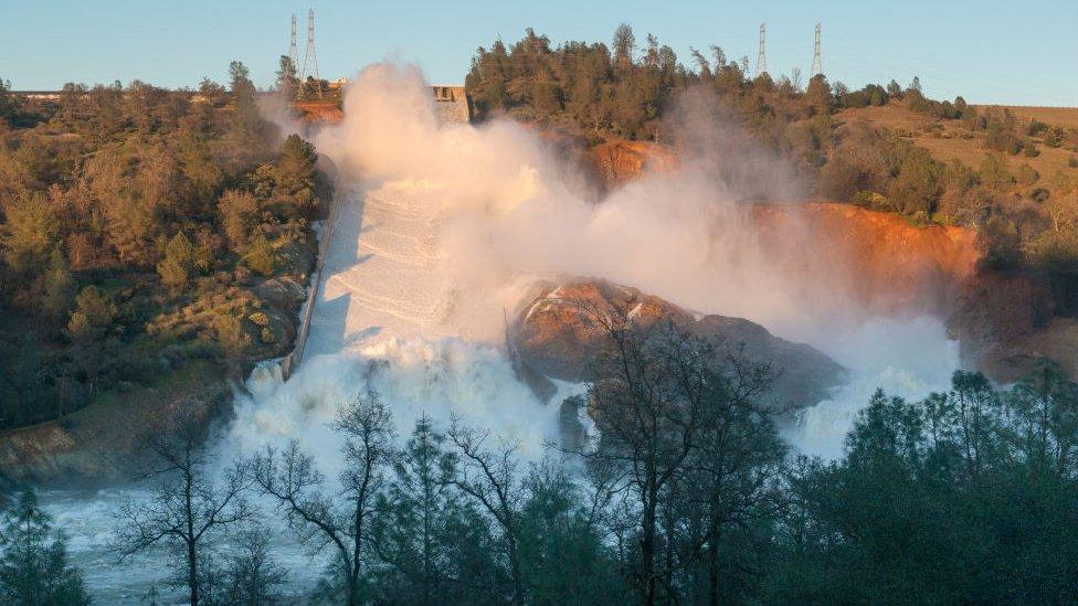 In this handout provided by the California Department of Water Resources (pixel.water.ca.gov), The heavy flows from the 3,000-foot main Oroville dam spillway continues to push debris into the turbid Feather River as the concrete span further eroded and the jagged fracture in its midsection sends water flowing over an adjacent hillside February 11, 2017 in Oroville, California.