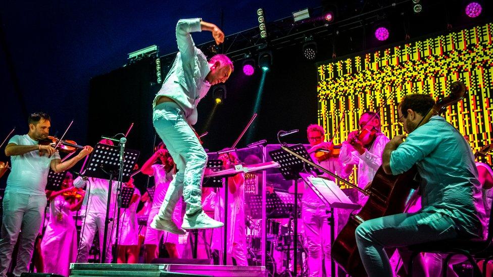 A man jumping on a brightly coloured stage