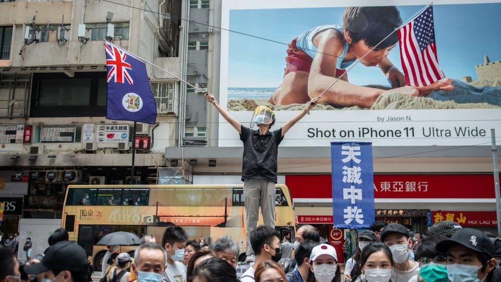 A protestor waving the US and Hong Kong colonial-era flags