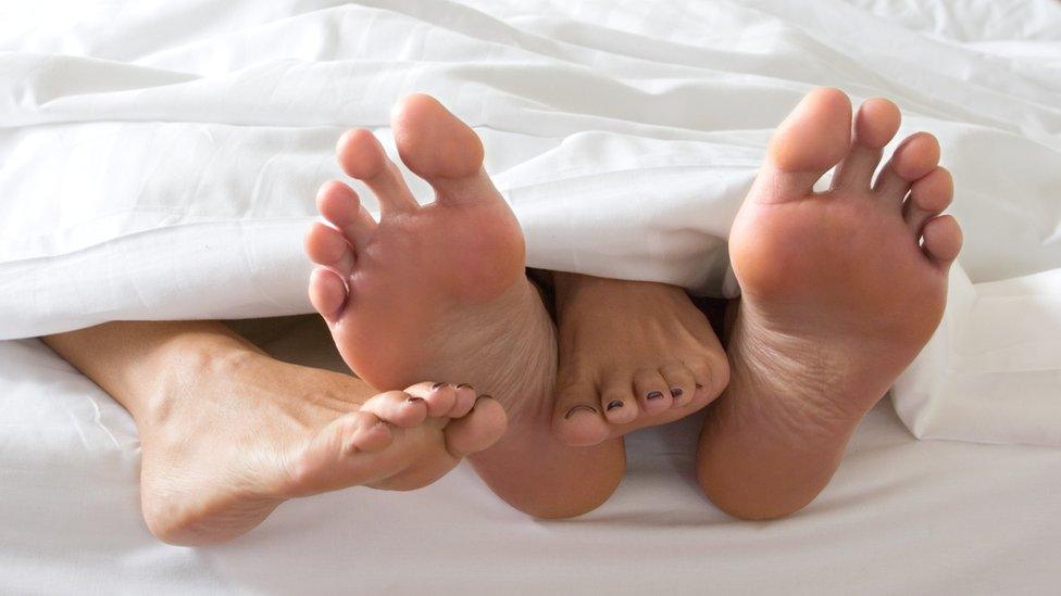 Feet of a couple in bed