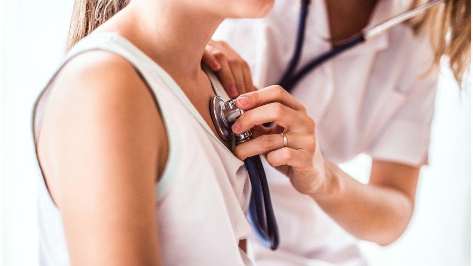 Doctor checking child's chest