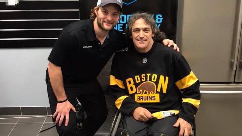 Darren Belling pictured in a wheelchair, next to a friend