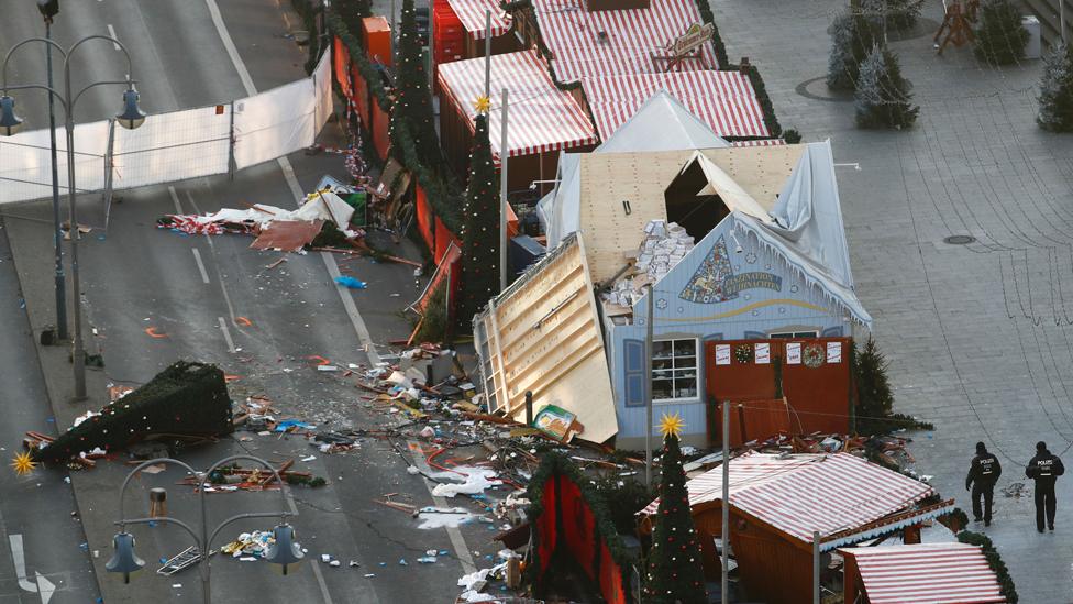 Police patrol inside the Christmas market area and past the destroyed booths two days after an attack with a truck in front of the Kaiser-Wilhelm-Gedaechtniskirche (Kaiser Wilhelm Memorial Church) in Berlin on December 21, 2016.