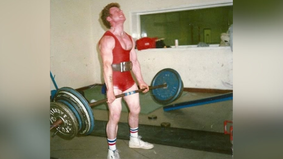 An archive picture of Alan Gutteridge lifting a barbell in the gym.