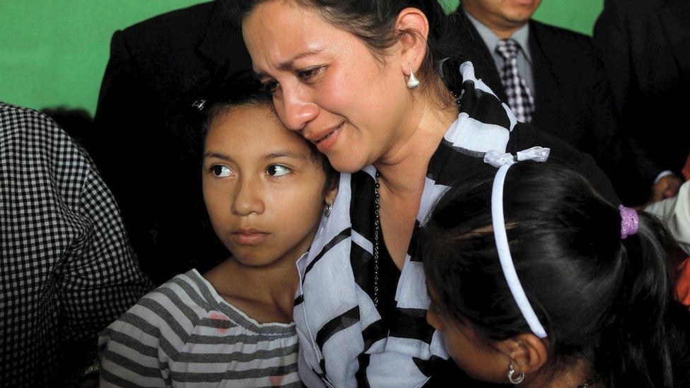 Family members of Juan Fernando Galindo, member of the National Coordinator for Disasters Reduction (CONRED), react as they receive a medal during his wake in Alotenango, Guatemala