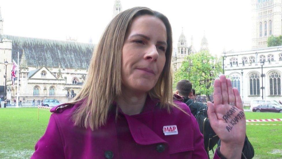 Melanie Ward holding up her hand with the name of her colleague's 13-year-old niece who died