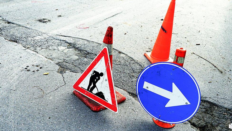 Two traffic cones and two signs