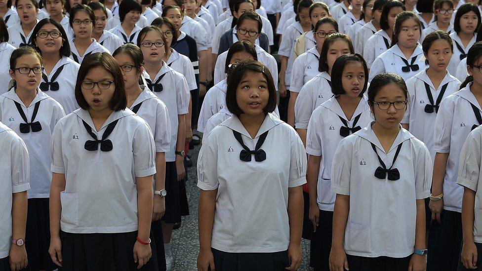 Thai schoolgirls gather for morning assembly and sing the national anthem