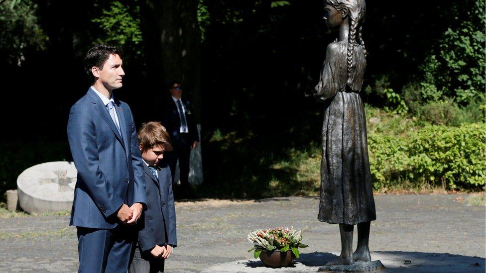 Justin Trudeau and his son Xavier place flowers at a monument for Holodomor victims in Kiev, Ukraine, July 11, 2016