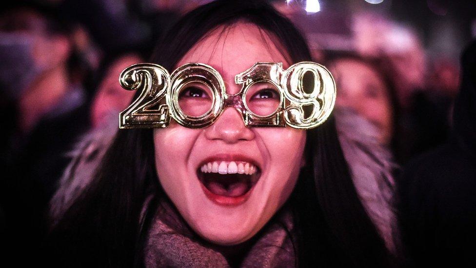 A woman watches fireworks explode over the London Eye in London